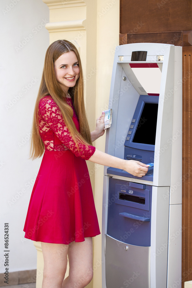 Blonde lady using an automated teller machine Blonde lady using an automated teller machine