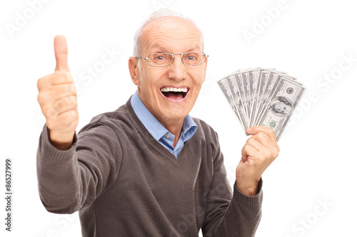 Excited senior holding money and giving a thumb up