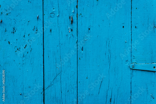 Wooden texture of blue color with scratches and cracks, which can be used as a background