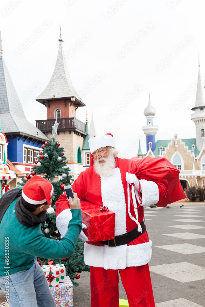 Obraz premium Man taking a photo to santa claus