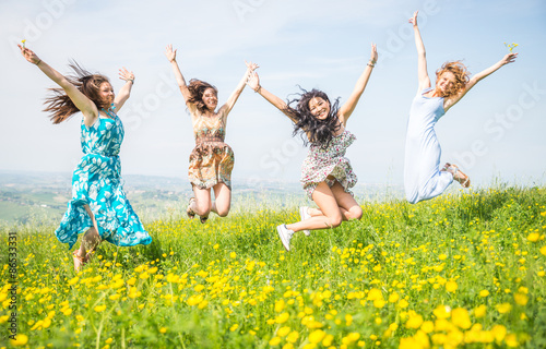 four girls jumping in the nature. concept about airiness and carefree.