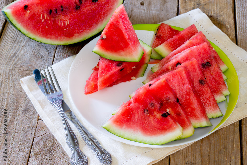 Fresh slices of watermelon on a plate on the wooden table