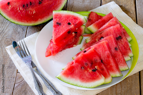Fresh slices of watermelon on a plate on the wooden table