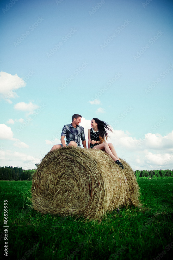 lovers resting in a field near haystacks
lovers resting in a field near haystacks
