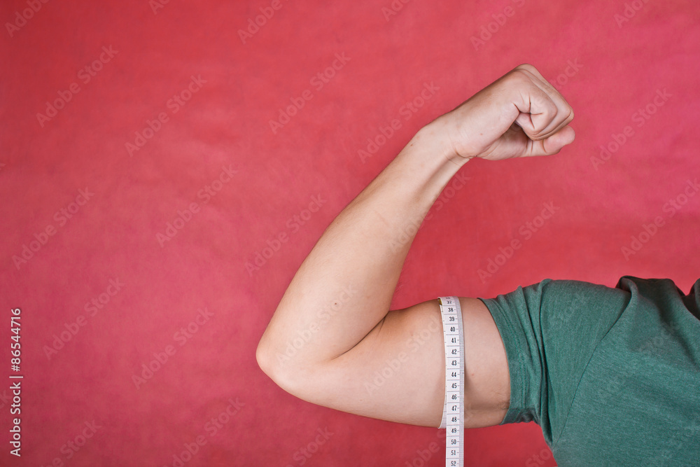 Measuring biceps. Slim muscled man.