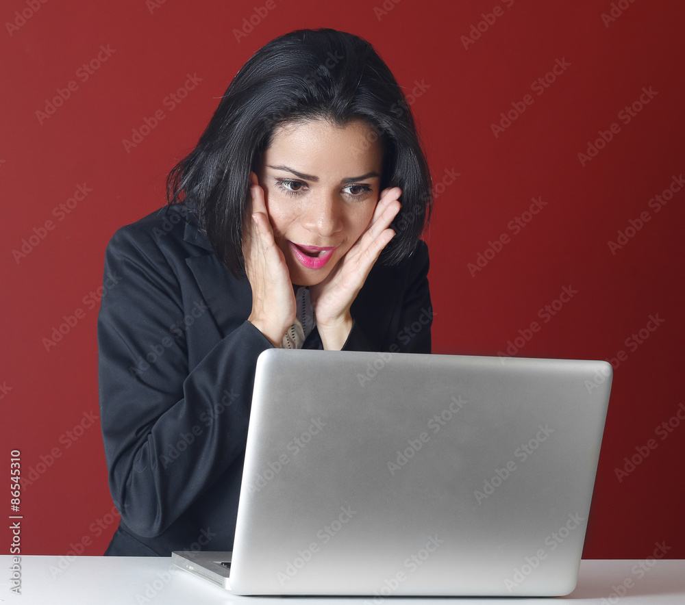 Young business woman looking surprised using computer Young business woman looking surprised using computer