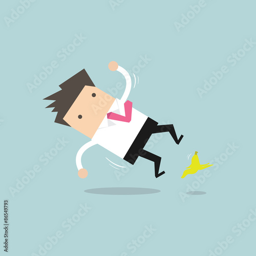 Businessman slipping on a banana peel and falling down