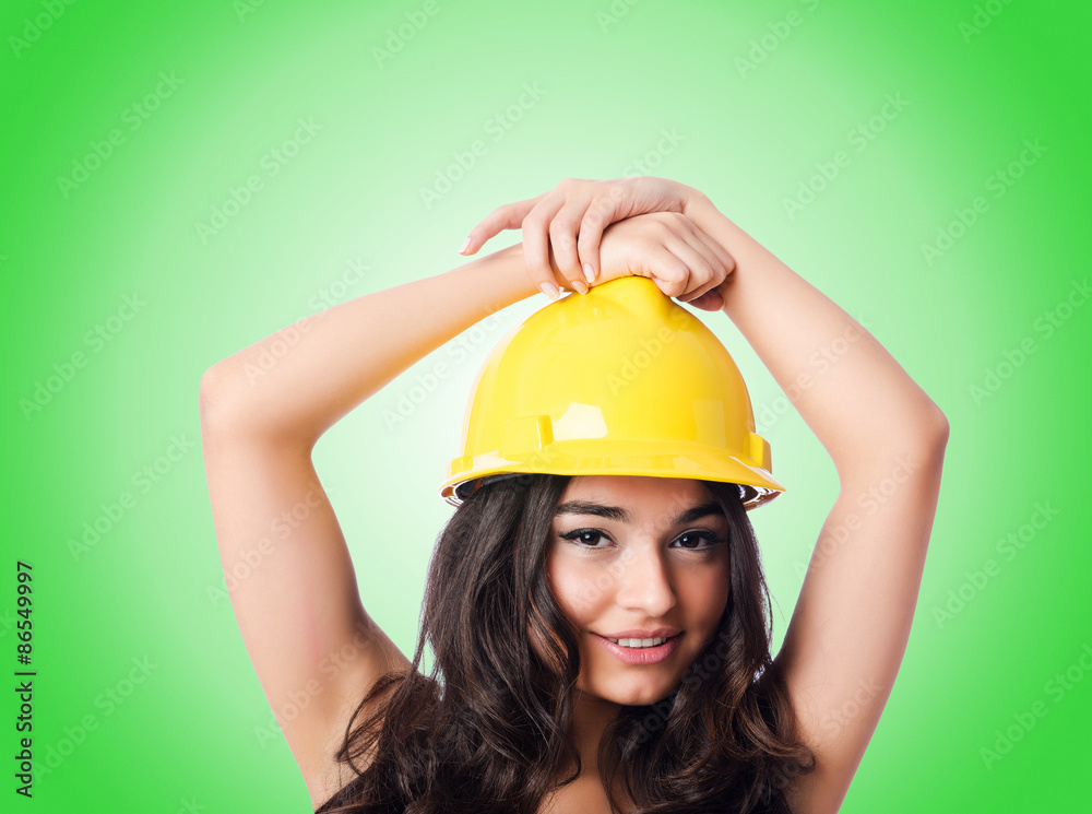 Young woman with hellow hard hat against gradient Young woman with hellow hard hat against gradient