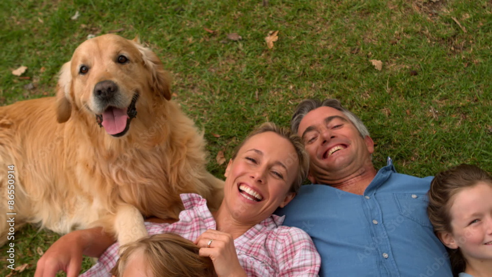 Happy family smiling at the camera with their dog Happy family smiling at the camera with their dog