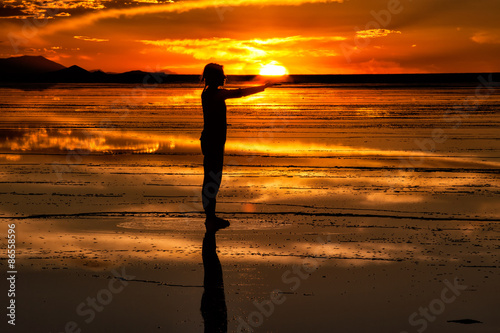 silhouette di una donna che riceve il sole  nelle mani. Salares de Uyuni, Bolivia photo