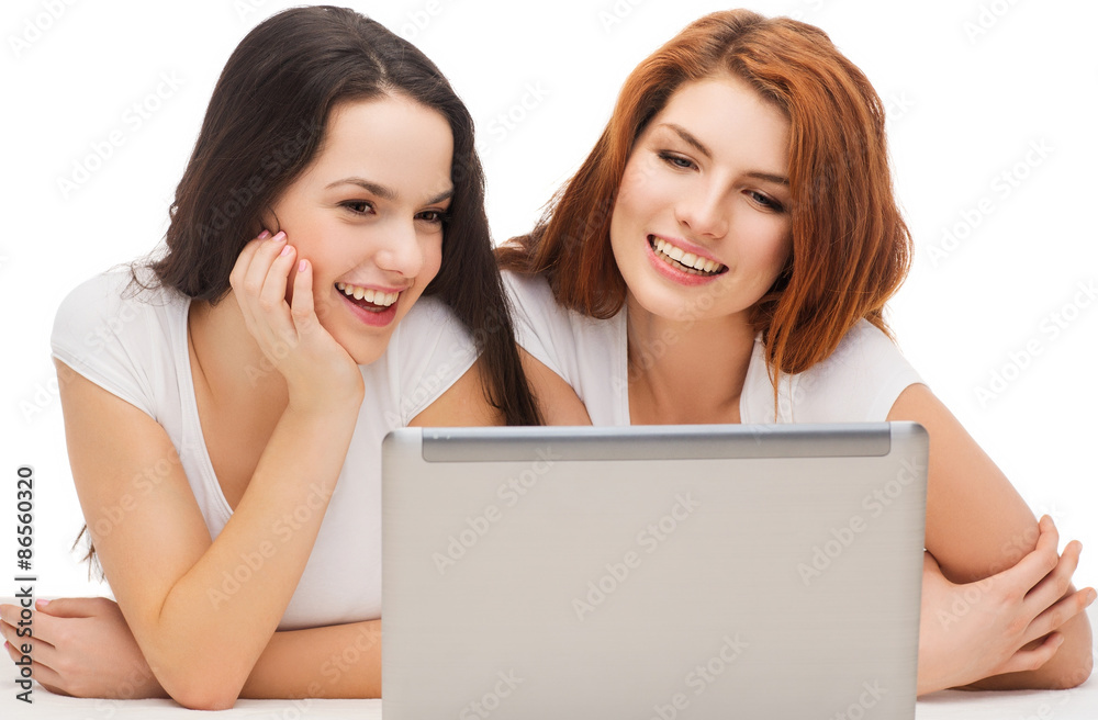 two smiling teenage girls with laptop computer two smiling teenage girls with laptop computer