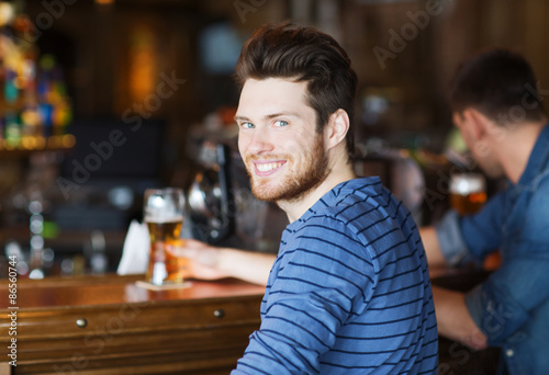 Sticker happy young man drinking beer at bar or pub