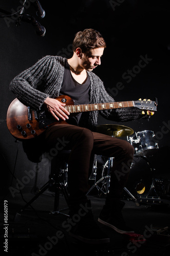 Man playing guitar in dark room