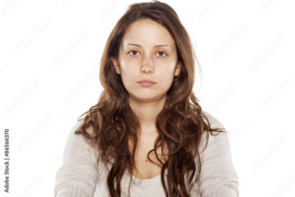 Serious young woman without makeup on a white background Serious young woman without makeup on a white background