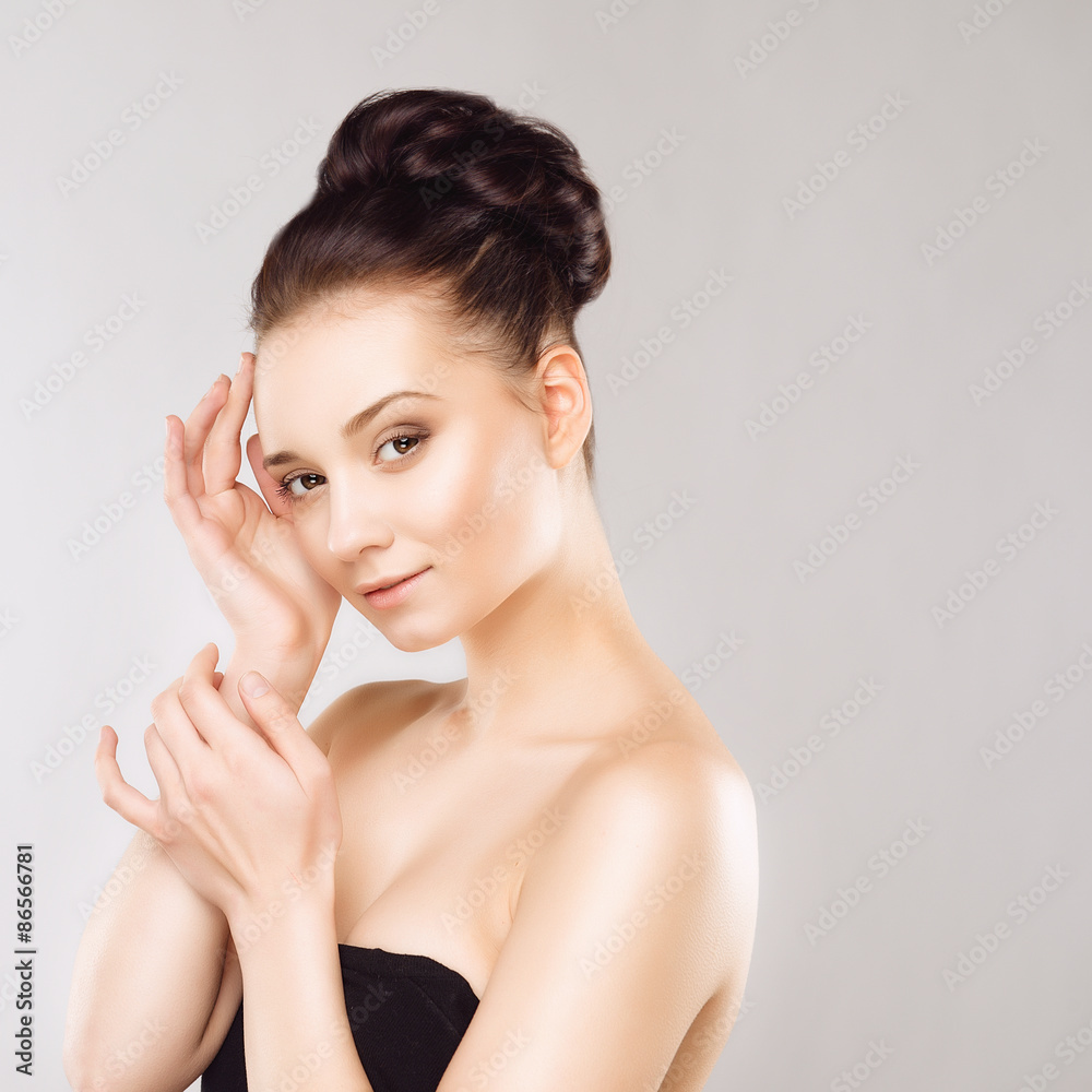 Portrait of Beautiful Young Woman with Clean Fresh Skin and Nude MakeUp. Isolated on Grey Background. Close up Portrait of Beautiful Young Woman with Clean Fresh Skin and Nude MakeUp. Isolated on Grey Background. Close up