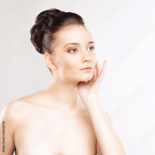 Portrait of Beautiful Young Woman with Clean Fresh Skin and Nude MakeUp. Isolated on White Background. Close up