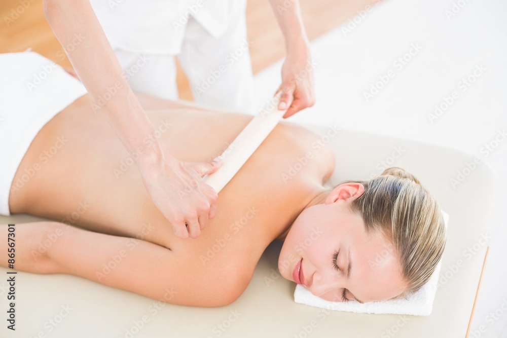 Therapist waxing womans back at spa center Therapist waxing womans back at spa center