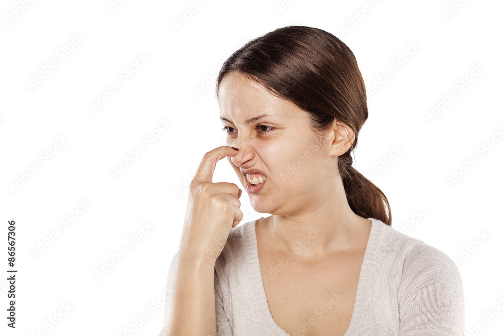 young woman scratching her nose on a white background young woman scratching her nose on a white background