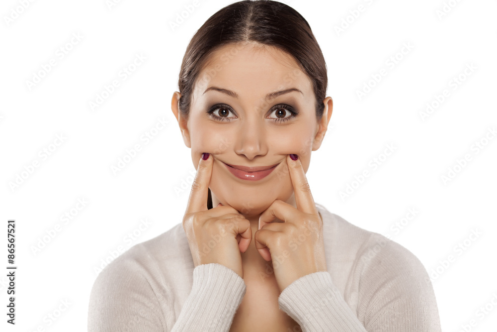 Beautiful young woman forced a smile with her fingers Beautiful young woman forced a smile with her fingers