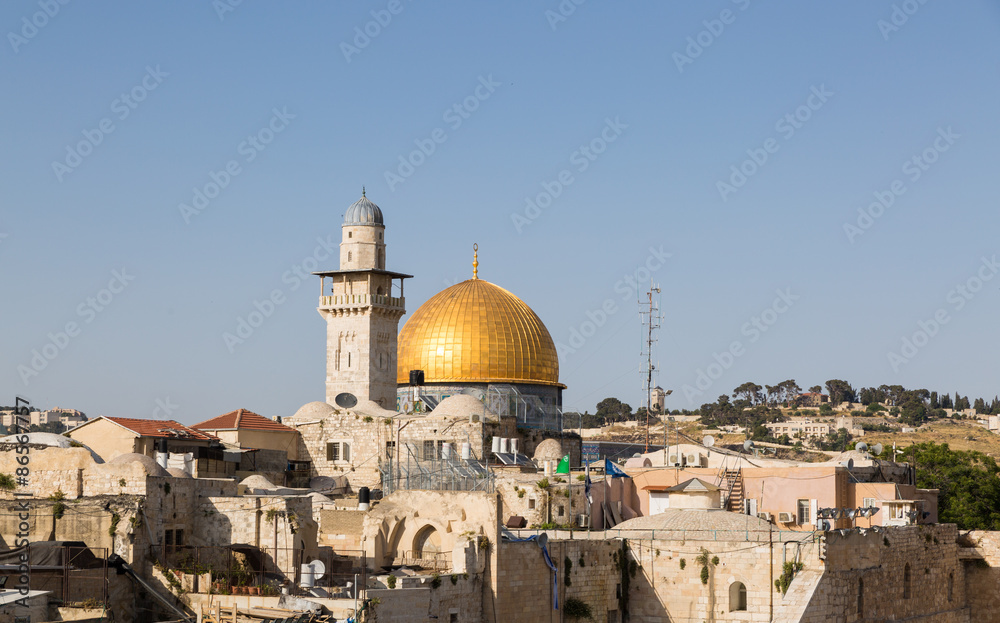 The mosque of Al-aqsa, minaret and roofs in Jerusalem with doves in sky