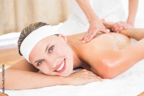 Pretty blonde enjoying a massage smiling at camera