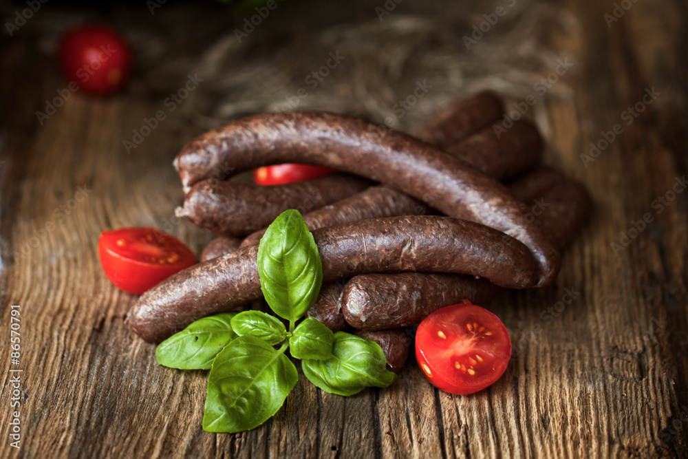 Black pudding, with cut slices, on chopping board over stone background. Krupniok really Polish black pudding.