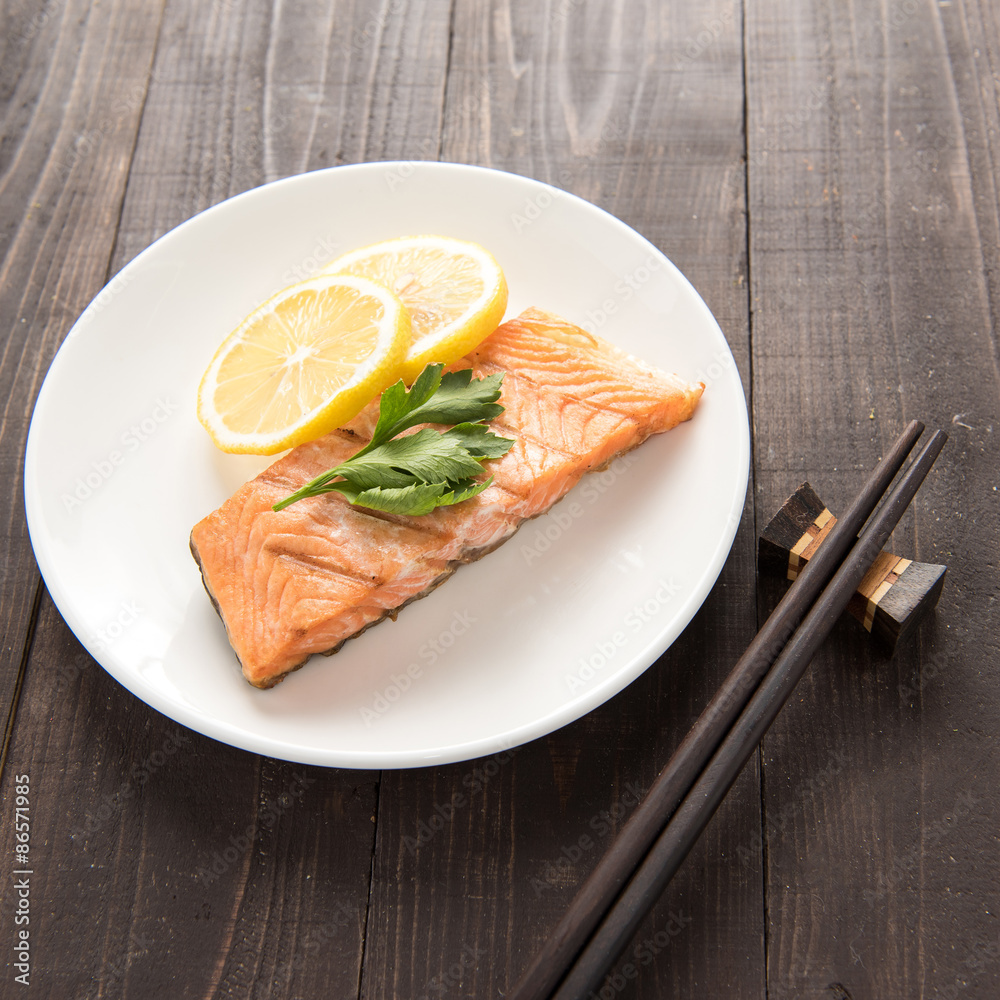 Grilled salmon with lemon on wooden table Grilled salmon with lemon on wooden table