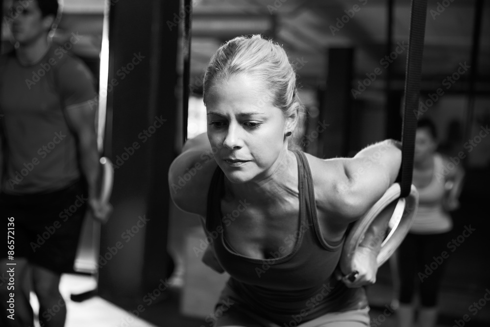 Black And White Shot Of Woman Using Gymnastic Rings In Gym