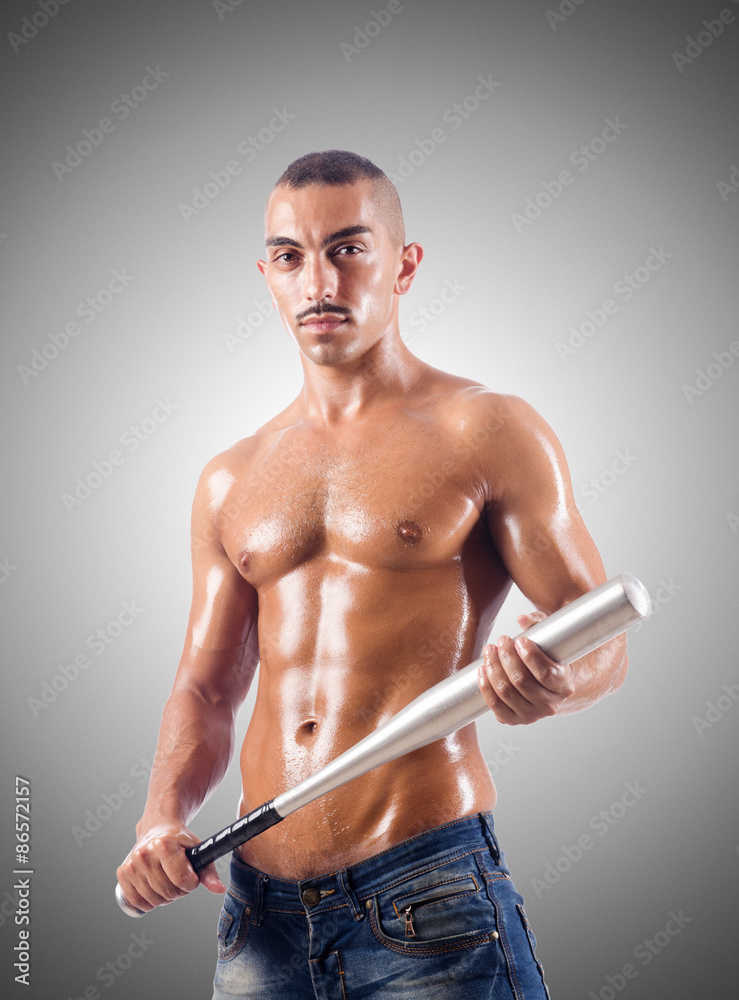Muscular man with baseball bat against gradient Muscular man with baseball bat against gradient