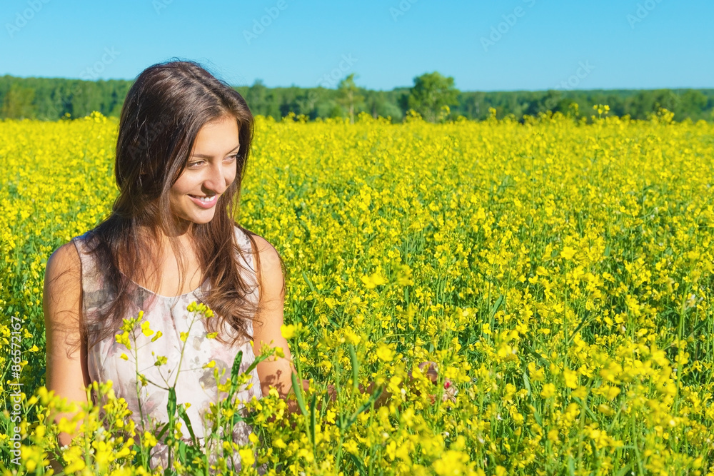 Portrait of a beautiful young woman among blossoming field Portrait of a beautiful young woman among blossoming field