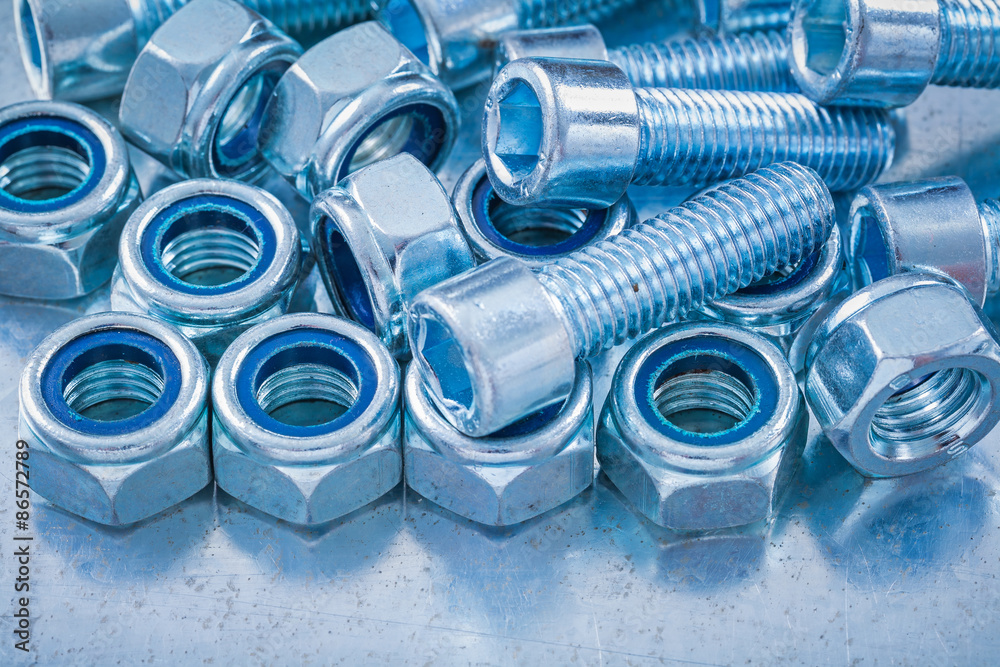 Close up view of threaded construction nuts and screw bolts on m Close up view of threaded construction nuts and screw bolts on m