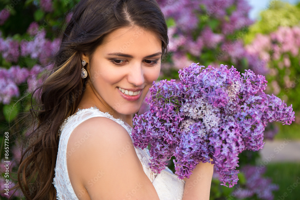 Fototapeta premium portrait of beautiful bride with big bouquet of lilac flowers