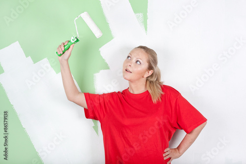 Young woman looking on paint roller