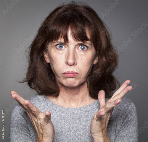 Fotografie closeup portrait of frustrated 50's woman losing faith, pouting with palm hands