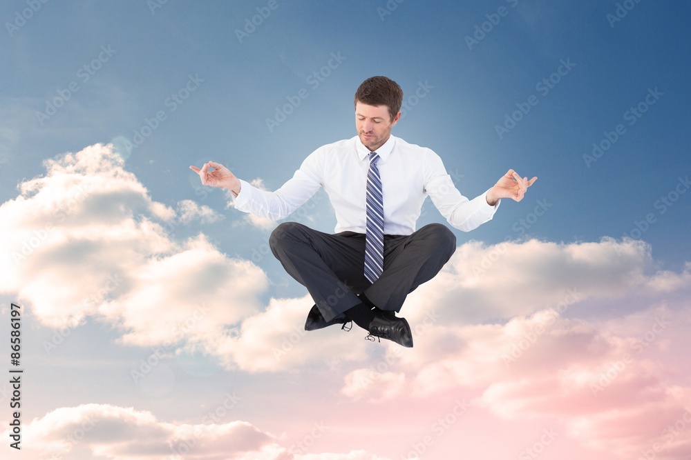 Composite image of businessman in suit sitting in lotus pose Composite image of businessman in suit sitting in lotus pose