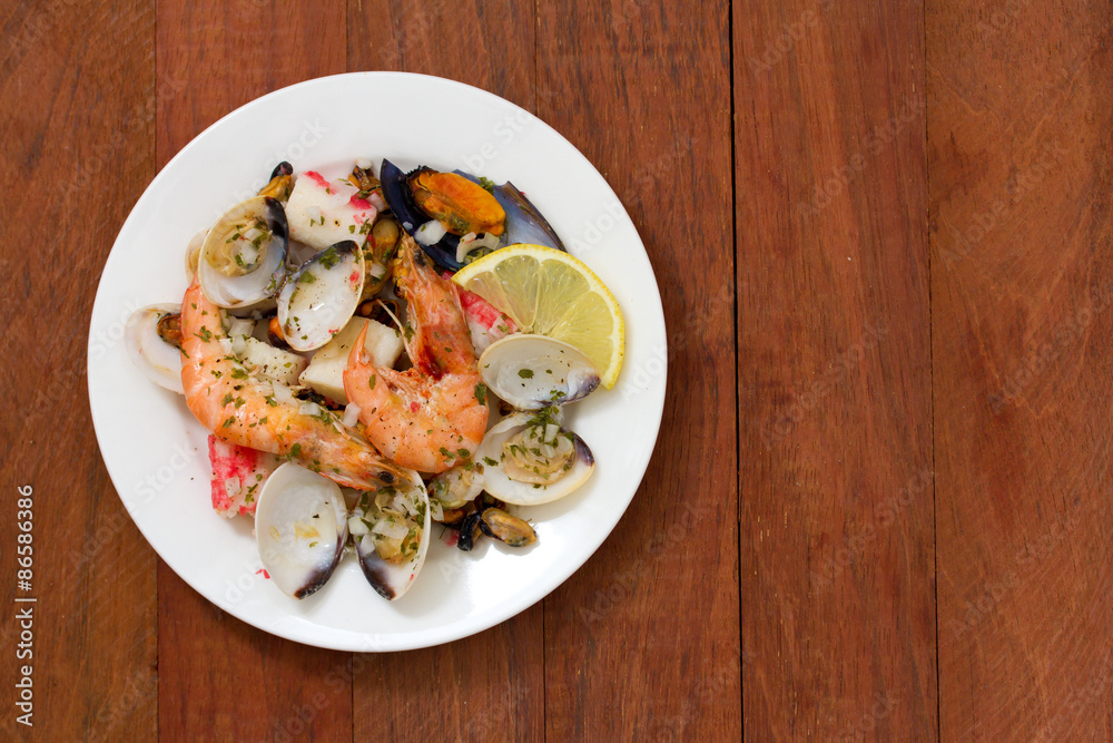 seafood salad on plate on brown wooden background seafood salad on plate on brown wooden background