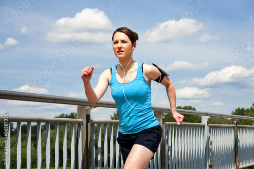 young girl running in the city, over the river by the bridge © Wisiel