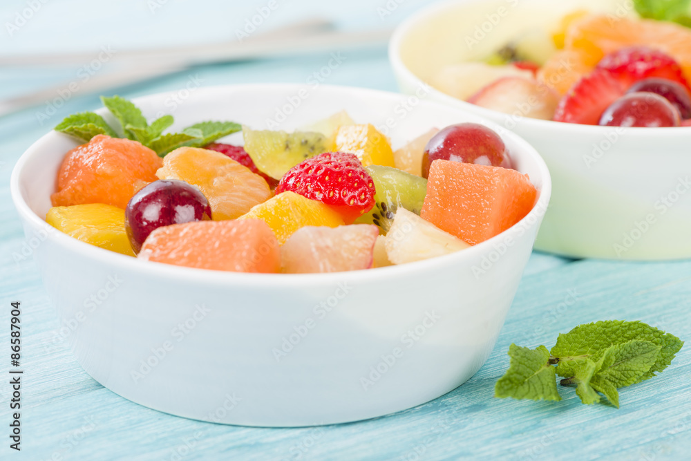 Fruit Salad - Bowls of fresh fruit salad on a blue background. Fruit Salad - Bowls of fresh fruit salad on a blue background.