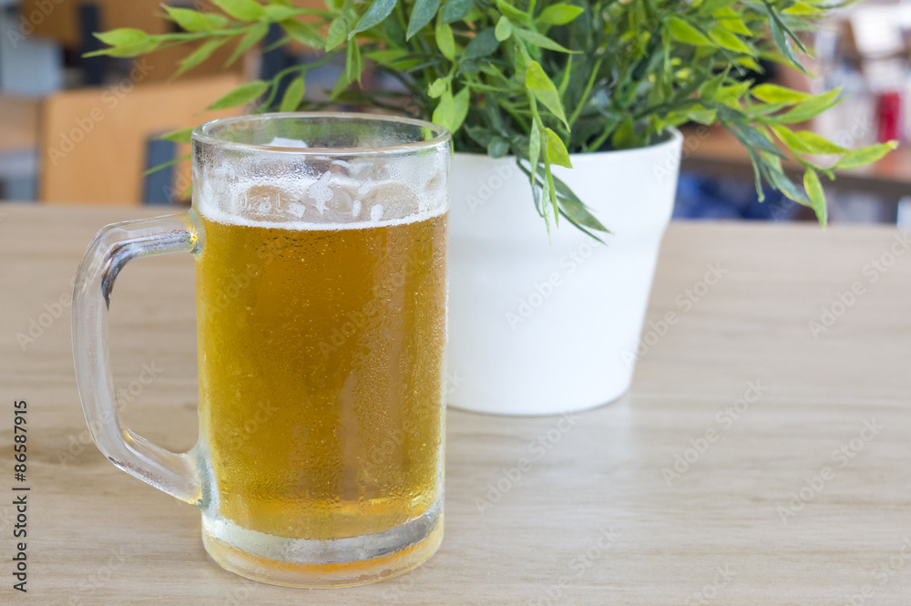 Beer mug filled with fresh draught beer on a table Beer mug filled with fresh draught beer on a table