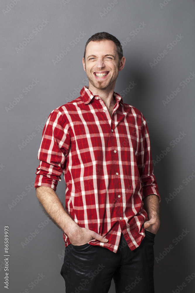 thrilled middle age man with goatee laughing for fun and relaxed attitude with hands in jeans pockets thrilled middle age man with goatee laughing for fun and relaxed attitude with hands in jeans pockets