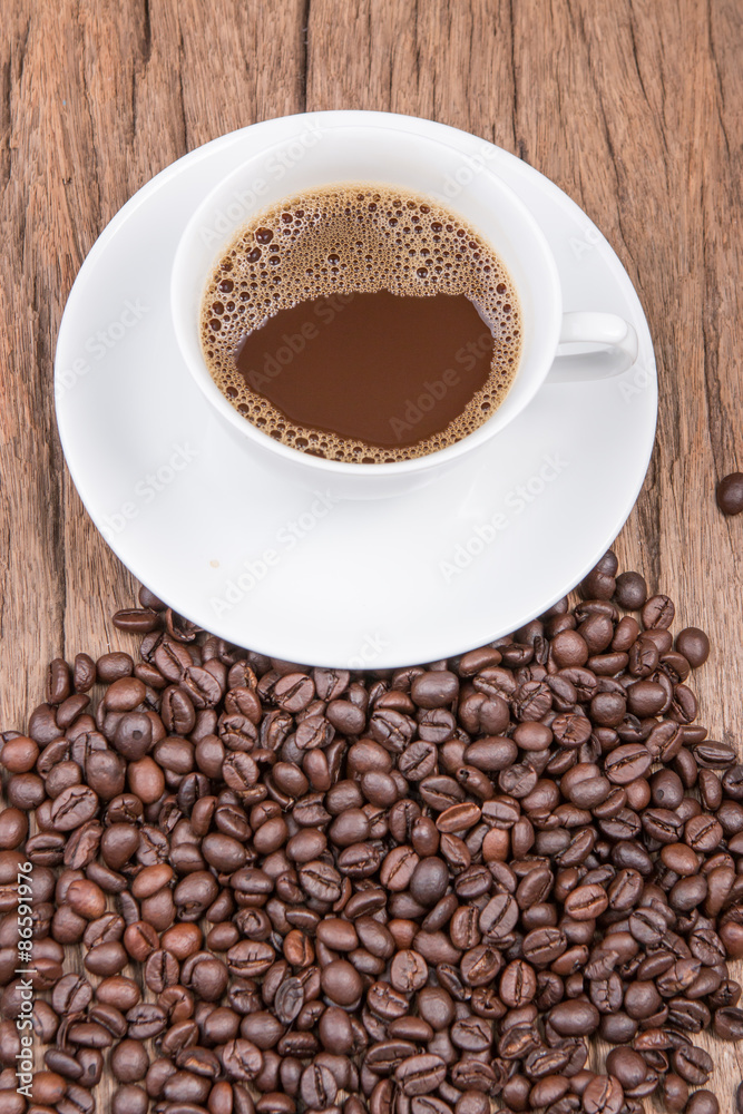 Cup of black coffee and coffee beans on wooden background Cup of black coffee and coffee beans on wooden background