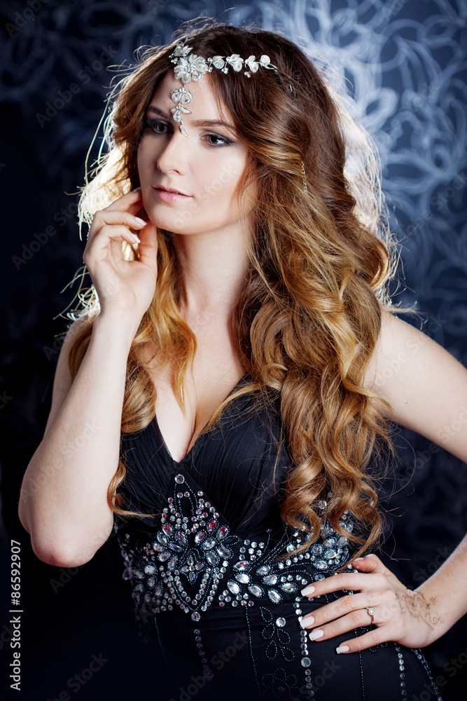 beautiful girl  with long brown curled hair, dark background