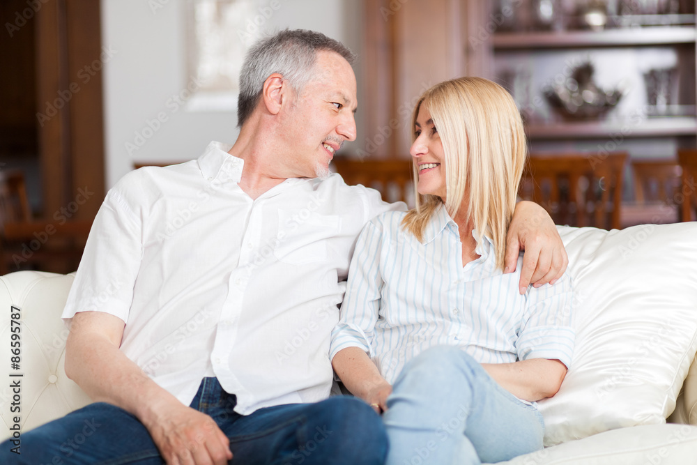 Senior Couple Relaxing On Sofa At Home Senior Couple Relaxing On Sofa At Home