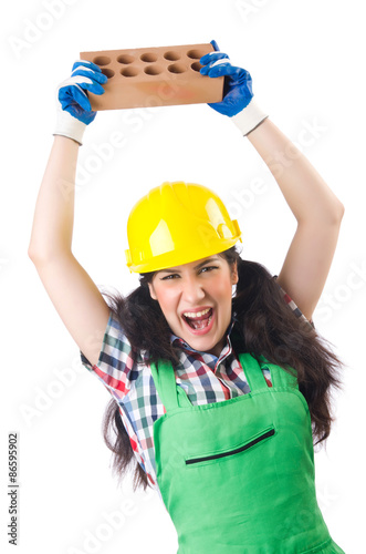 Female workman in green overalls holding brick isolated on white