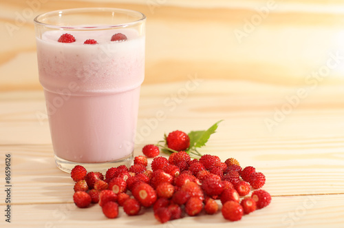 Smoothie from wild strawberries in a glass and wild strawberries