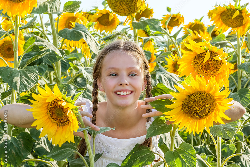 Cheerful girl hiding in the sunflowers Cheerful girl hiding in the sunflowers