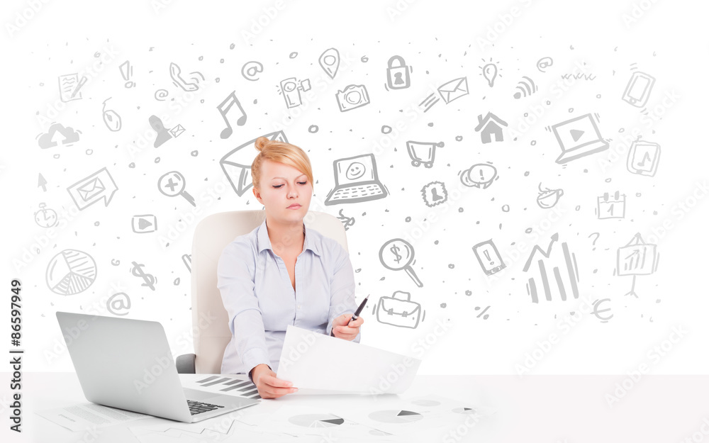 Business woman sitting at table with hand drawn media icons Business woman sitting at table with hand drawn media icons