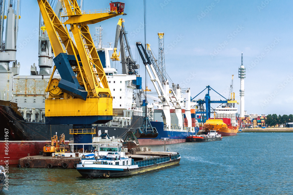 Großes Schwerlast-Container-Schiff  mit kleineren Schiffen im Hafen von Rotterdam