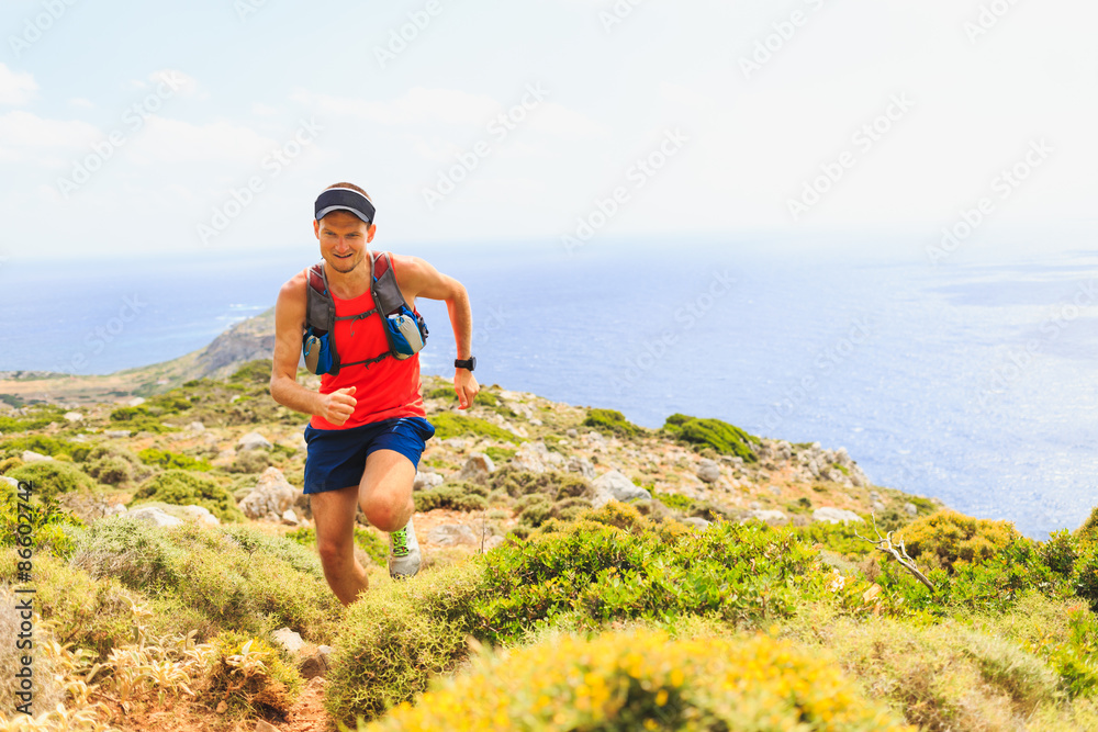 Happy trail running man in beautiful mountains