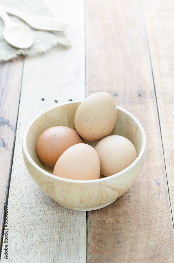 Eggs in wood bowl on wooden background Eggs in wood bowl on wooden background